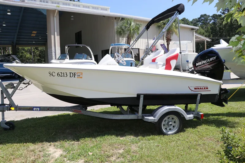 Slide: The Image of 2017 Boston Whaler 130 Super Sport boat on trailer, parked outdoors. - 4