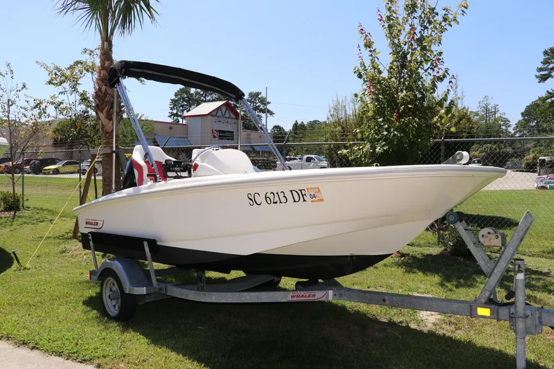 Slide: The Image of 2017 Boston Whaler 130 Super Sport boat on trailer, parked outdoors. - 1