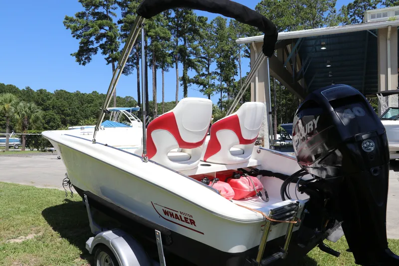Slide: The Image of 2017 Boston Whaler 130 Super Sport boat with Mercury engine, parked outdoors. - 5
