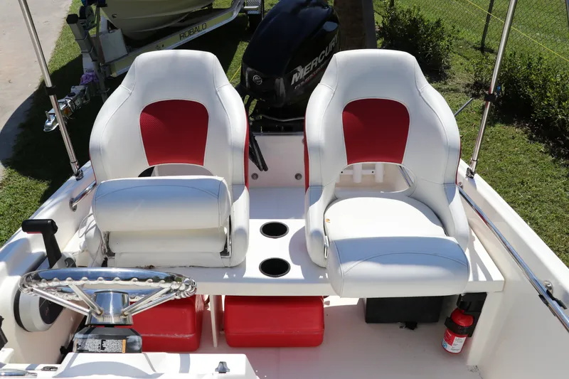 Slide: The Image of 2017 Boston Whaler 130 Super Sport boat interior with red and white seating. - 12