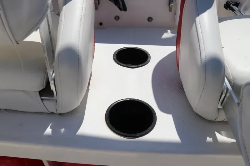 Slide: The Image of 2017 Boston Whaler 130 Super Sport interior with dual cup holders and white seating. - 14