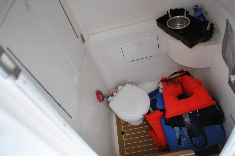 Slide: The Image of 2016 Regulator 28 Forward Seating boat interior with toilet and life jackets. - 41