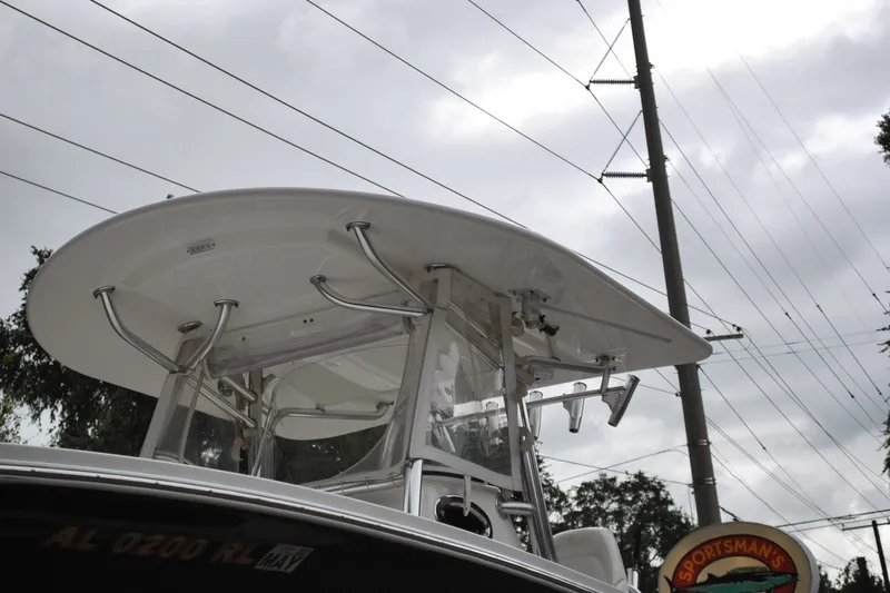Slide: The Image of 2016 Regulator 28 Forward Seating boat with T-top, under cloudy sky. - 51