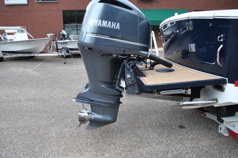 Slide: The Image of 2016 Regulator 28 Forward Seating boat with Yamaha outboard motor in a parking lot. - 49