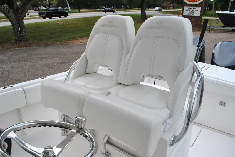 Slide: The Image of 2016 Regulator 28 Forward Seating boat with dual white captain's chairs and steering wheel. - 30