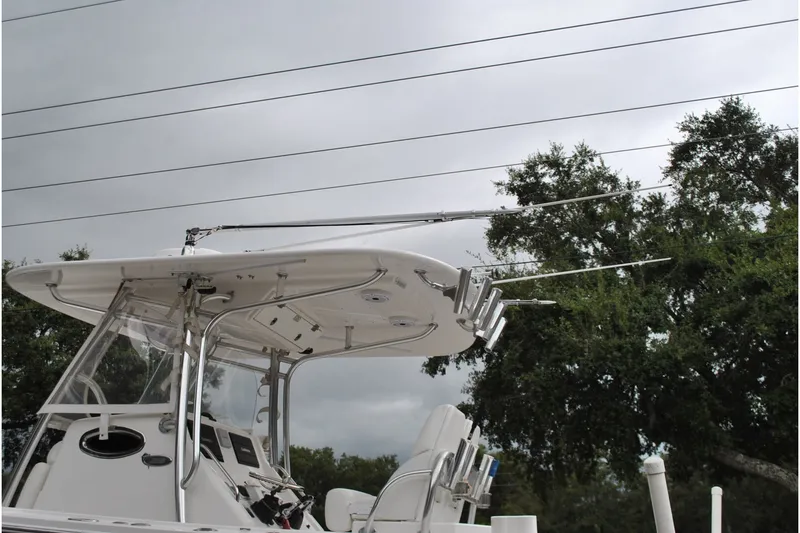 Slide: The Image of 2016 Regulator 28 Forward Seating boat with T-top and outriggers against cloudy sky. - 52