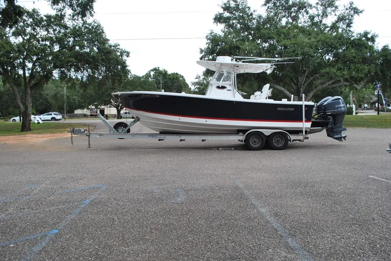 Slide: The Image of 2016 Regulator 28 Forward Seating boat on trailer in parking lot. - 2