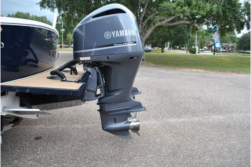 Slide: The Image of 2016 Regulator 28 Forward Seating boat with Yamaha outboard motor in a parking area. - 48
