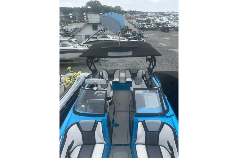 Slide: The Image of 2021 Yamaha Boats 255XE, blue and gray interior, docked at a marina. - 14