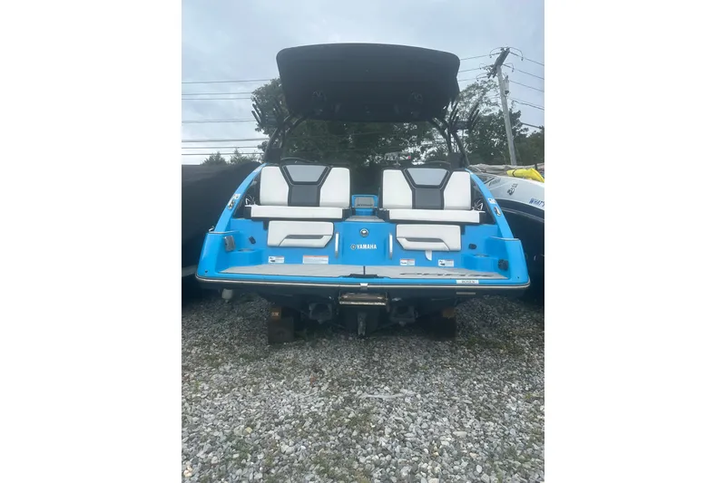 Slide: The Image of 2021 Yamaha Boats 255XE, blue and white, rear view on gravel surface. - 3
