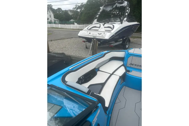 Slide: The Image of 2021 Yamaha Boats 255XE with sleek interior and exterior design, parked on a trailer. - 19