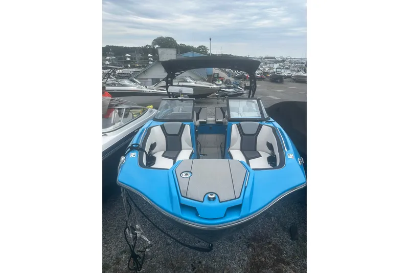 The Image of 2021 Yamaha Boats 255XE, blue and white, parked in a marina. - 1