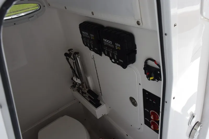 Slide: The Image of Interior of 2023 Sea Hunt Gamefish 27CB boat, featuring electrical components and a compact toilet. - 19
