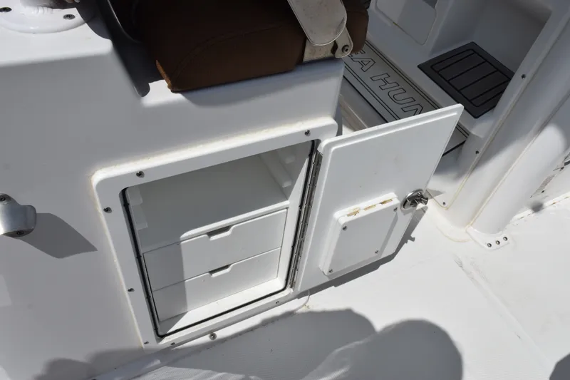 Slide: The Image of 2023 Sea Hunt Gamefish 27CB boat storage compartment with open door and drawers. - 29