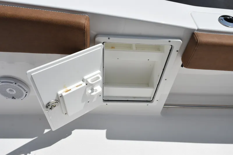 Slide: The Image of Open storage compartment on 2023 Sea Hunt Gamefish 27CB boat, featuring brown cushioned seating. - 28