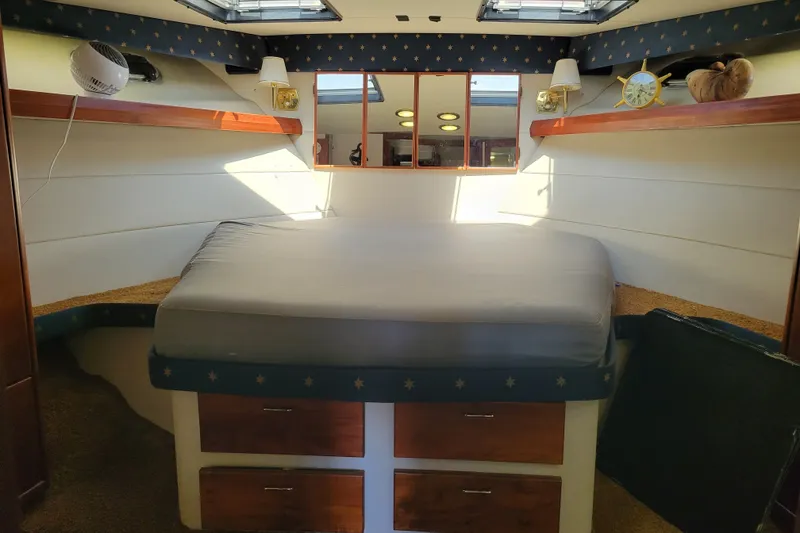 Slide: The Image of 1991 Bayliner 4588 Pilothouse cabin interior with bed, storage, and nautical decor. - 31