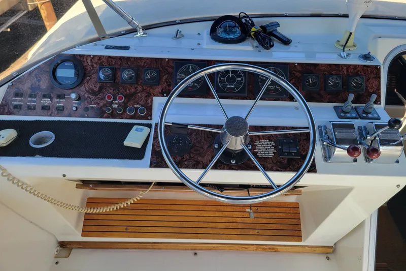 Slide: The Image of 1991 Bayliner 4588 Pilothouse helm with steering wheel and control panel. - 22