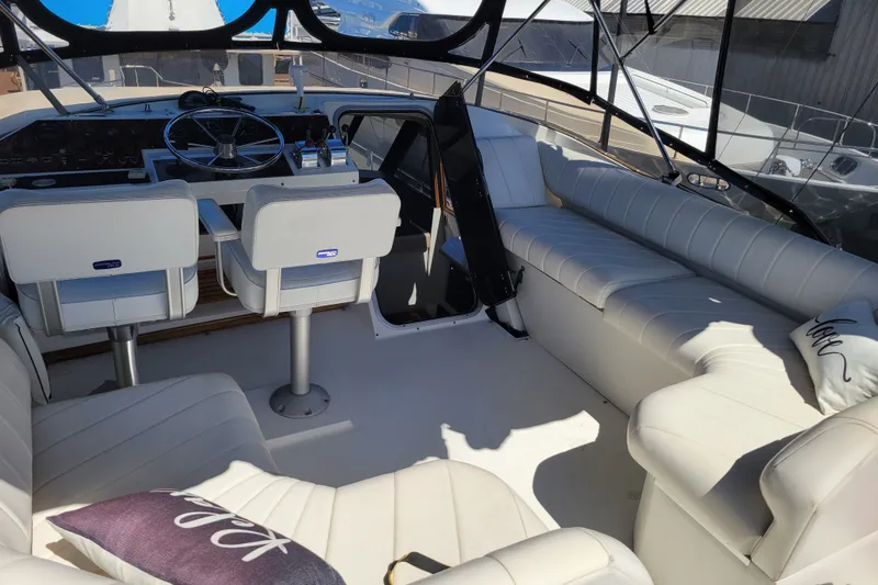 Slide: The Image of 1991 Bayliner 4588 Pilothouse interior with white seating and steering area. - 21