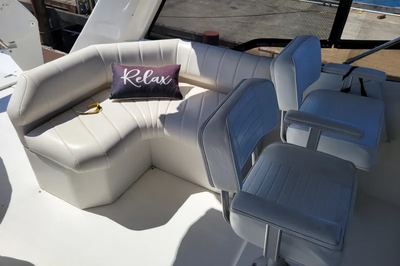 Slide: The Image of 1991 Bayliner 4588 Pilothouse interior with white seating and "Relax" pillow. - 23