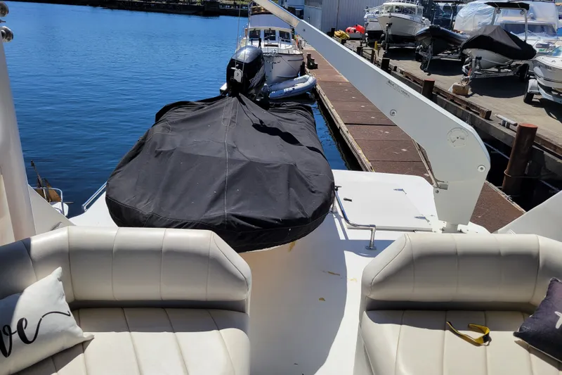 Slide: The Image of 1991 Bayliner 4588 Pilothouse yacht docked, featuring covered seating and water view. - 24