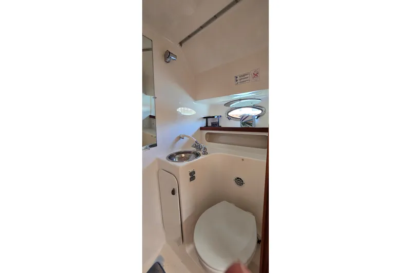 Slide: The Image of Interior of 2000 Tiara Yachts 3100 Open, featuring compact bathroom with sink and toilet. - 20