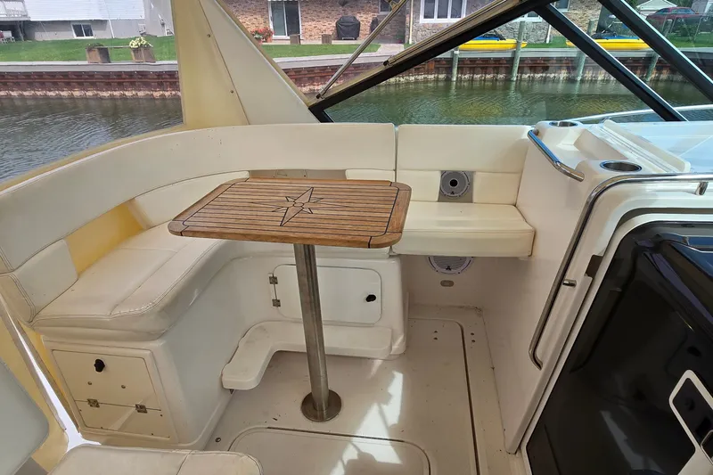 Slide: The Image of 2000 Tiara Yachts 3100 Open interior with cushioned seating and wooden table. - 13