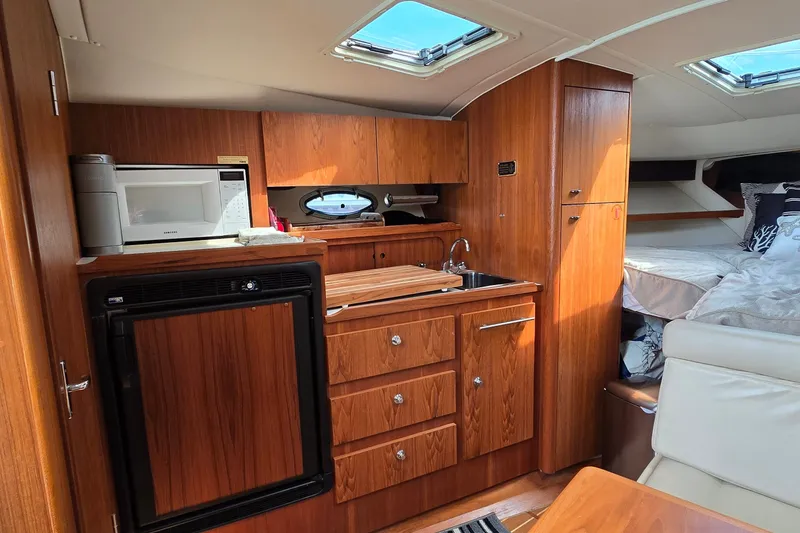 Slide: The Image of Interior of 2000 Tiara Yachts 3100 Open with kitchenette and cozy sleeping area. - 16
