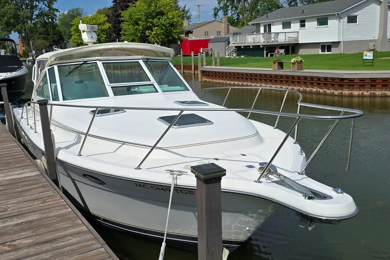 The Image of 2000 Tiara Yachts 3100 Open docked in a serene canal setting. - 1