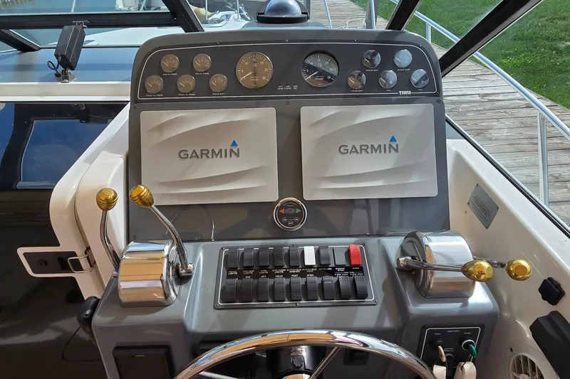 Slide: The Image of Cockpit of 2000 Tiara Yachts 3100 Open with Garmin navigation system and control panel. - 11