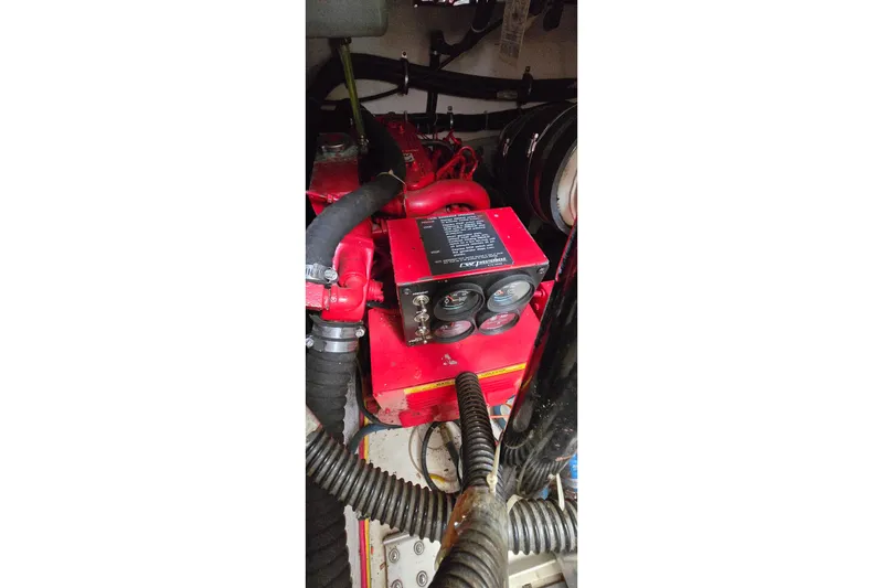 Slide: The Image of Engine compartment of a 2000 Tiara Yachts 3100 Open, featuring red engine components. - 28