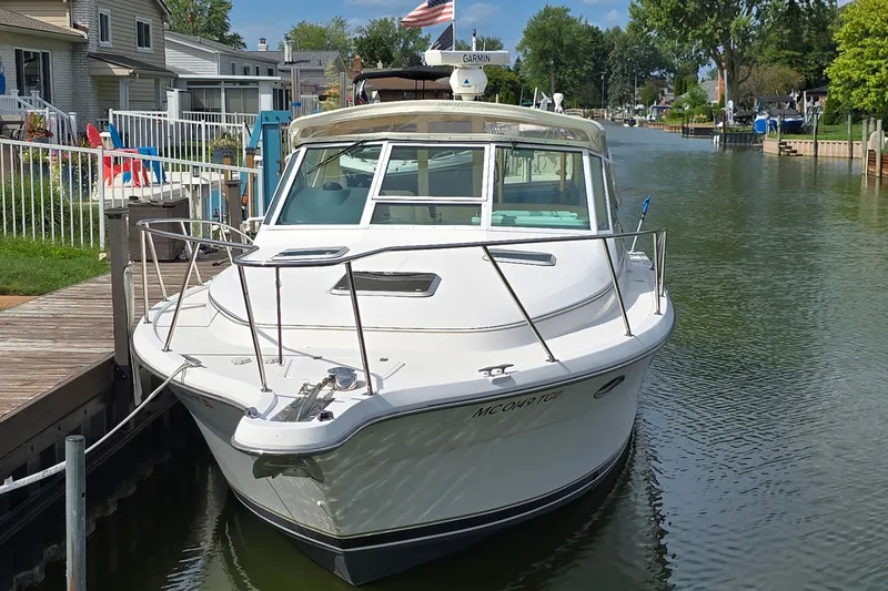 Slide: The Image of 2000 Tiara Yachts 3100 Open docked in a serene canal setting. - 4