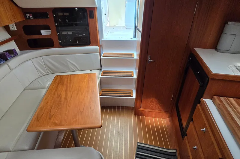 Slide: The Image of Interior of a 2000 Tiara Yachts 3100 Open, featuring wood accents and seating area. - 26