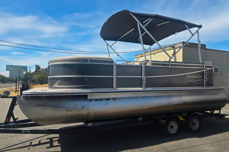 Slide: The Image of 2013 Cypress Cay Seabreeze 210 pontoon boat on trailer under blue sky. - 16