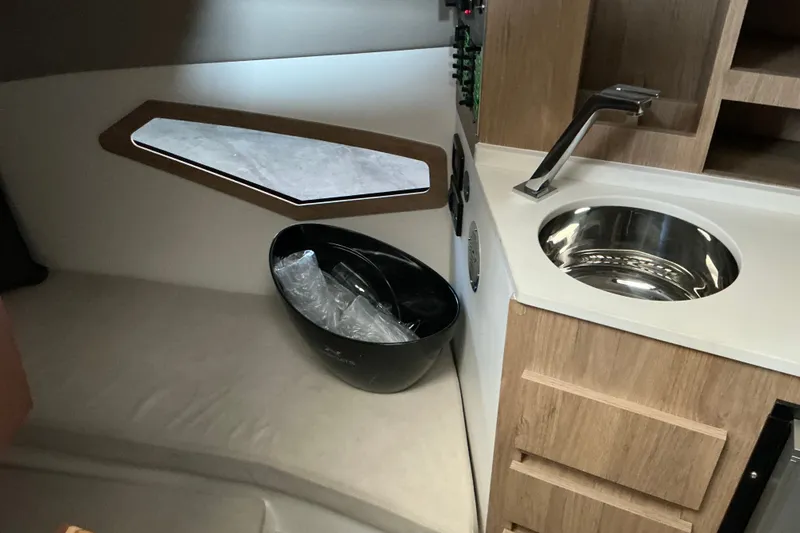 Slide: The Image of Interior of 2027 NX Boats 350 Maximus featuring a compact kitchenette with sink and storage. - 25