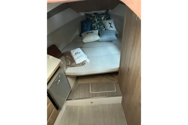 Slide: The Image of Interior cabin of 2027 NX Boats 350 Maximus, featuring cozy bedding and compact design. - 18