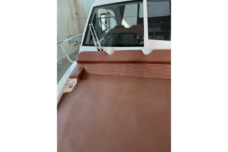 Slide: The Image of 2027 NX Boats 350 Maximus deck with brown seating and windshield. - 17