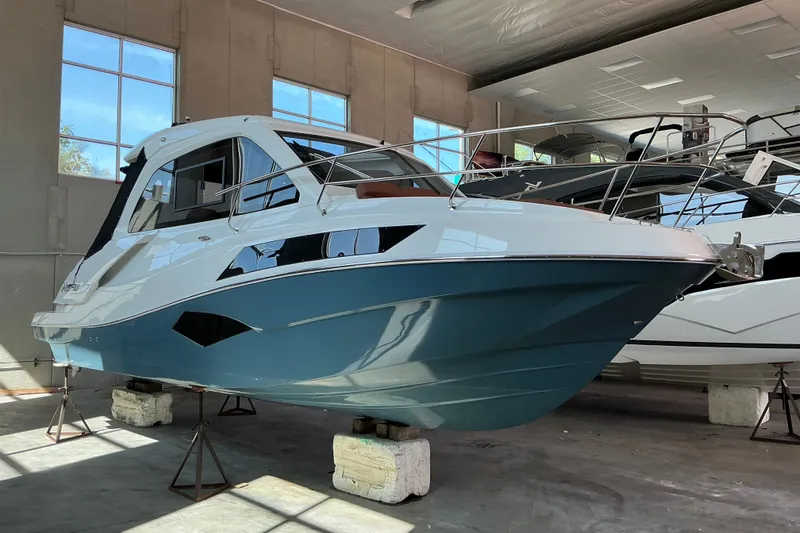 The Image of 2027 NX Boats 350 Maximus in showroom, sleek design, blue and white exterior. - 1