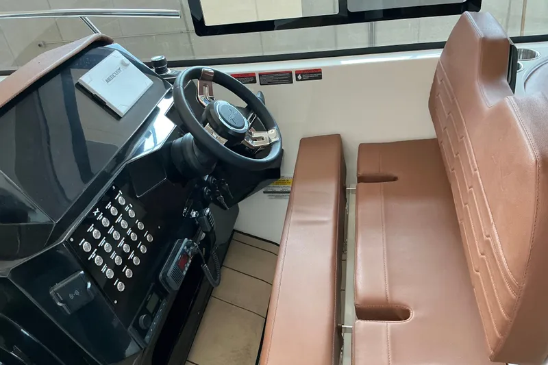 Slide: The Image of Interior view of 2027 NX Boats 350 Maximus helm with brown seating and control panel. - 15