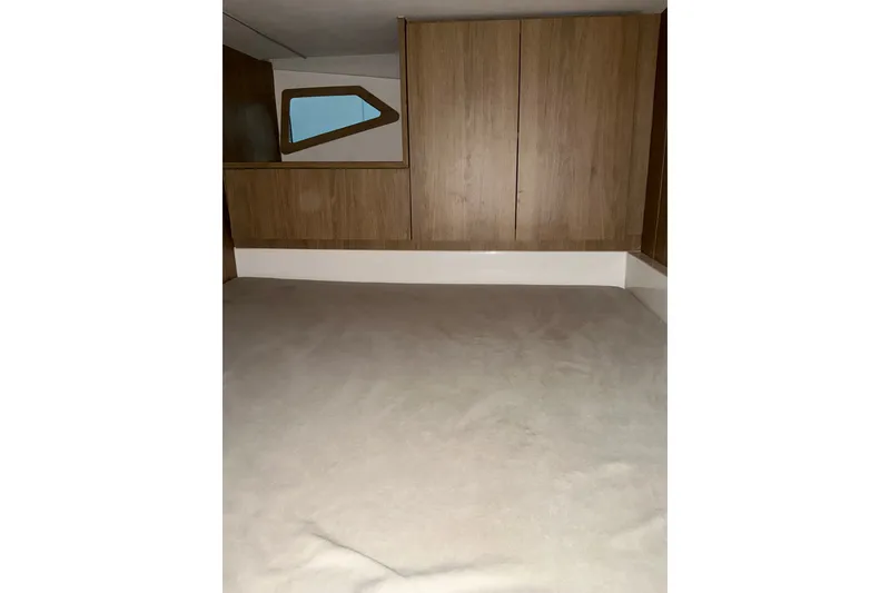 Slide: The Image of Interior cabin of 2027 NX Boats 350 Maximus, featuring wood paneling and a window. - 24
