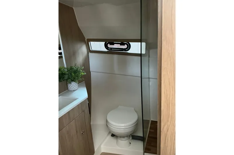 Slide: The Image of Bathroom interior of 2027 NX Boats 350 Maximus, featuring modern design and compact layout. - 26