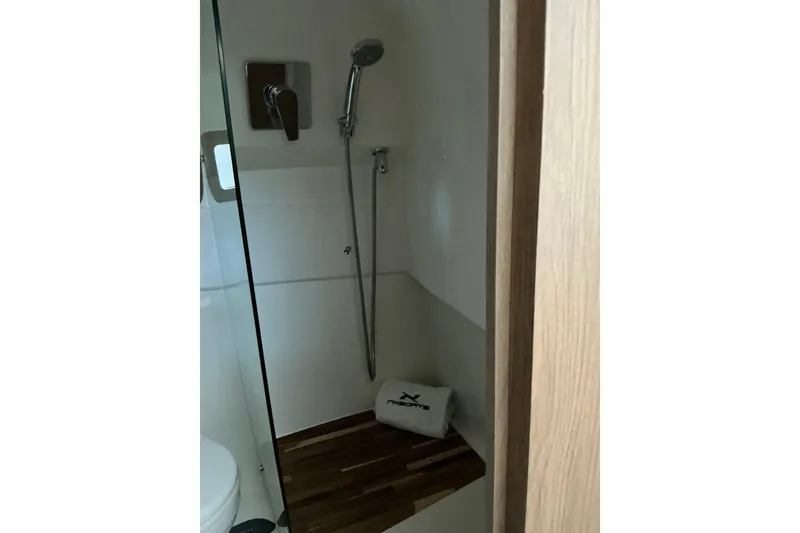 Slide: The Image of Shower area in 2027 NX Boats 350 Maximus, featuring modern fixtures and wooden accents. - 27