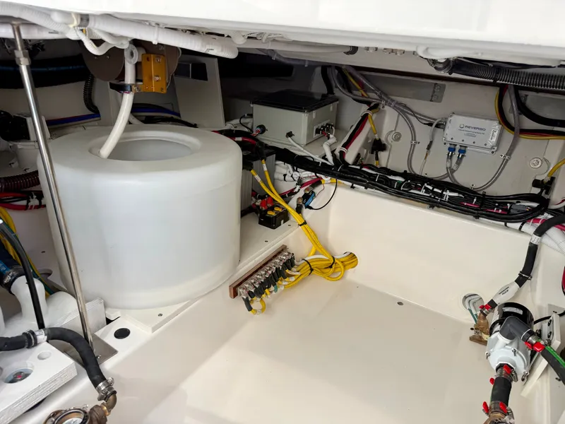 Slide: The Image of The engine room of a 2027 Tiara Yachts 39LS features cables, pipes, and a large white tank. - 41