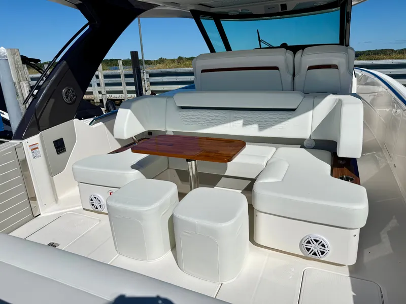 Slide: The Image of Tiara Yachts 39LS 2027: Luxurious seating area with white upholstery and a wooden table outdoors. - 9