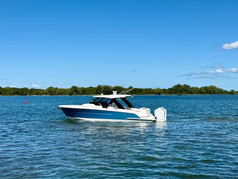 Slide: The Image of Tiara Yachts 39LS 2027 on calm water with blue sky and green shoreline. - 1