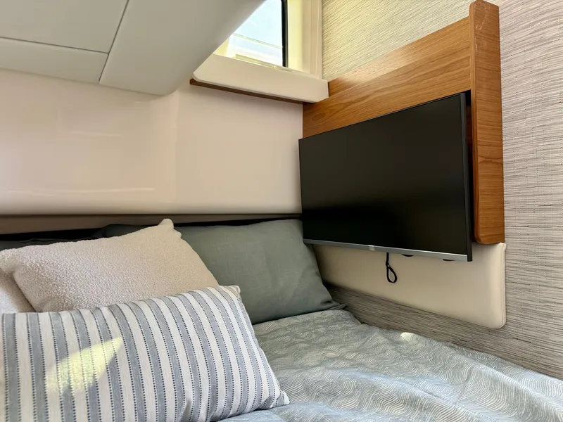 Slide: The Image of Cozy cabin with a bed, pillows, and a wall-mounted TV. - 29