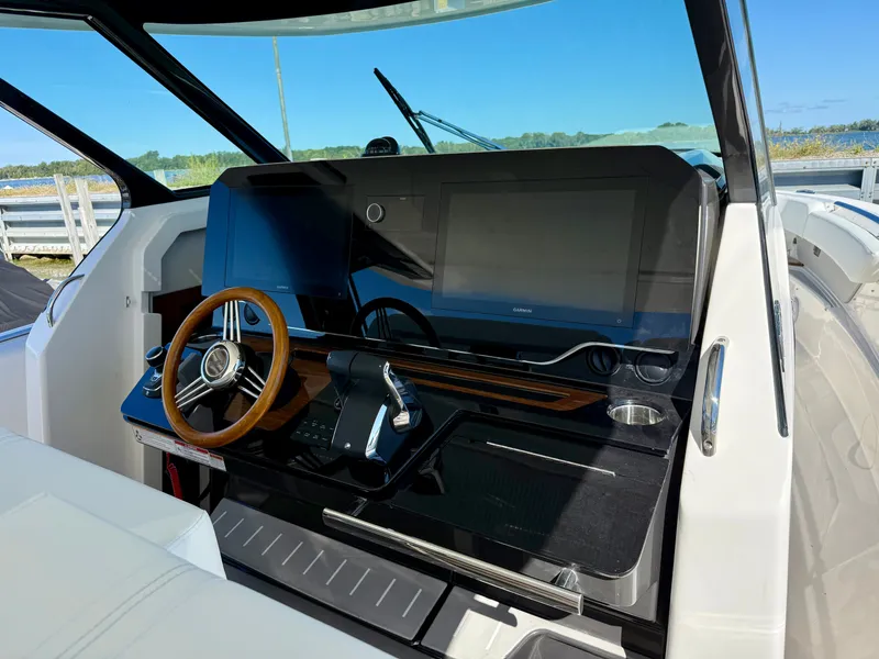 Slide: The Image of The 2027 Tiara Yachts 39LS cockpit features a modern helm with a wooden steering wheel. - 16