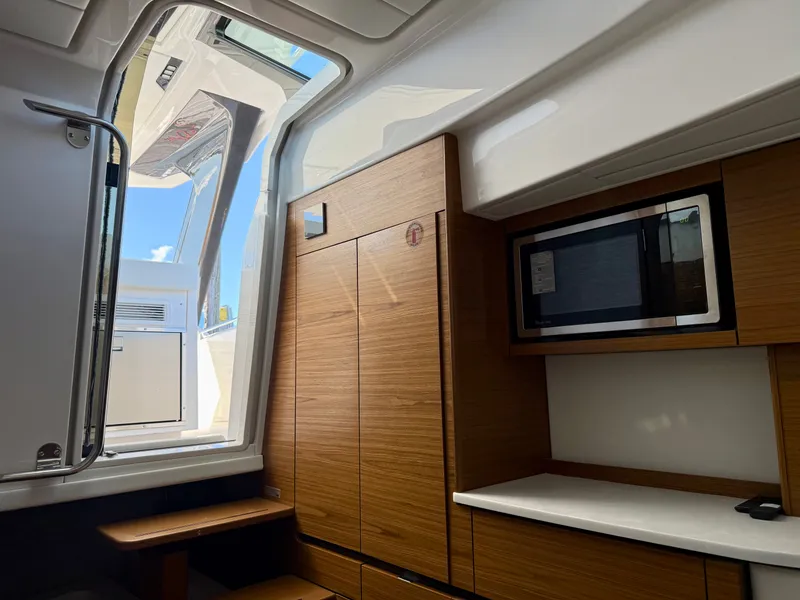 Slide: The Image of Interior of a 2027 Tiara Yachts 39LS with wooden cabinets and a microwave. - 30