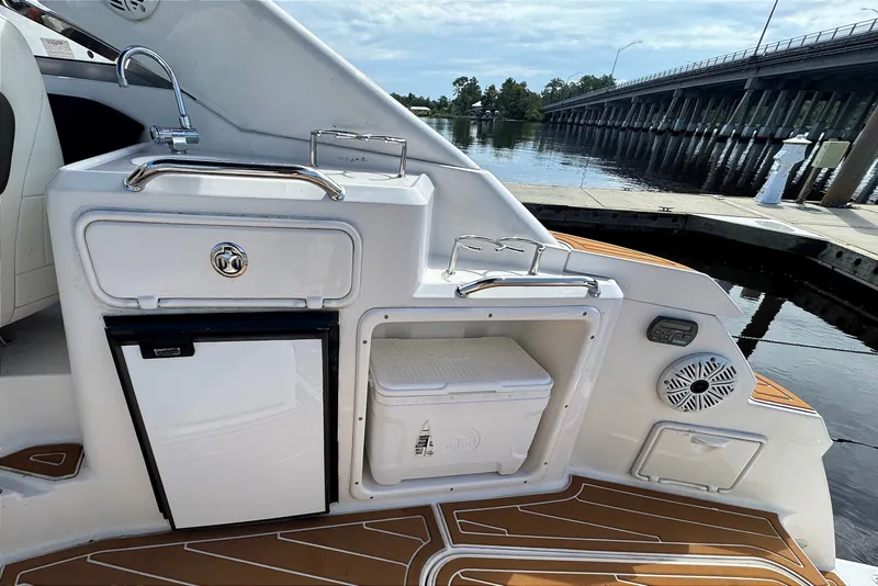 Slide: The Image of 2010 Regal 2860 Window Express boat interior with kitchenette and scenic waterfront view. - 11