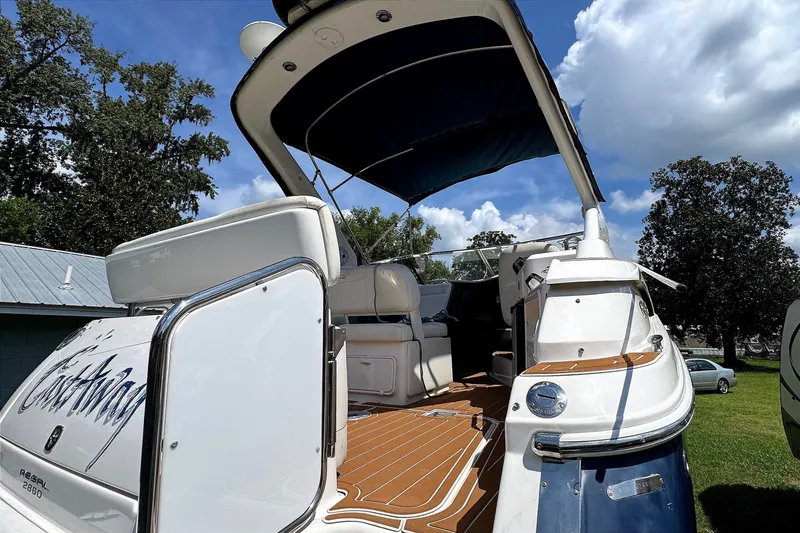 Slide: The Image of 2010 Regal 2860 Window Express boat with open deck, blue canopy, and sleek design. - 18