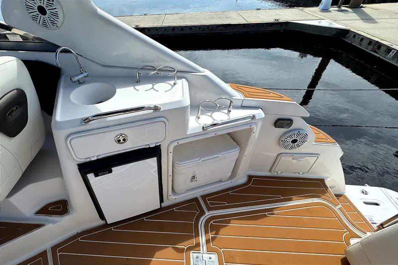 Slide: The Image of 2010 Regal 2860 Window Express boat interior with sink, fridge, and wood-patterned flooring. - 10